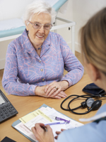 Senior woman patient with UK nurse Senior woman sitting with nurse